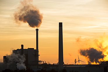 Sunset over the Iggesund paper board manufacturer in Workington, with wind turbines behind, Cumbria, England, United Kingdom, Europe