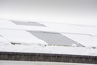 Solar panels covered in snow on a house roof in Ambleside, Lake District, Cumbria, England, United Kingdom, Europe