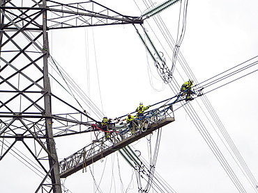 Technicians working to replace old insulators on a pylon in Barrow on Soar, Leicestershire, England, United Kingdom, Europe