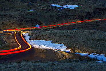 Car lights over Wrynose Pass at sunset, Lake District, Cumbria, England, United Kingdom, Europe