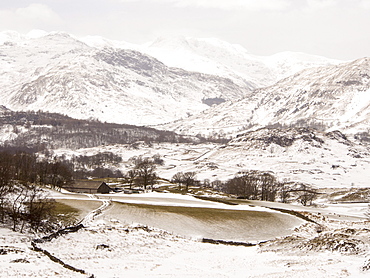 Fields scoured of snow by strong winds near Hawkshead, looking towards Bow Fell, Lake District National Park, Cumbria, England, United Kingdom, Europe