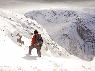 A walker on Gray Crag looking towards Stoney Cove Pike during unseasonally cold weather in late March 2013, Lake District, Cumbria, England, United Kingdom, Europe