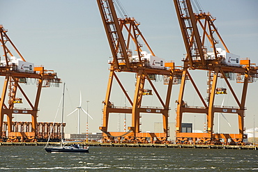 Dockside cranes with wind turbines behind, Amsterdam, Netherlands, Europe