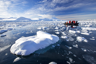 Members of an expedition cruise to Antarctica in a Zodiak in Fournier Bay in the Gerlache Strait on the Antarctic Peninsular. The Antarctic Peninsular is one of the most rapidly warming areas on the planet.