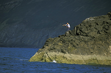 Fisherman casting fishing rod, Ynys Lochtyn, Ceredigion, Wales, UK, Europe 