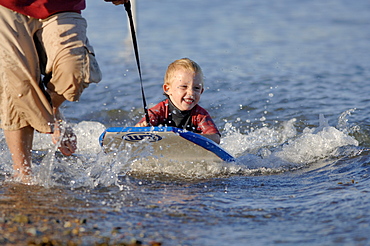 Young boy being towed on boogie board