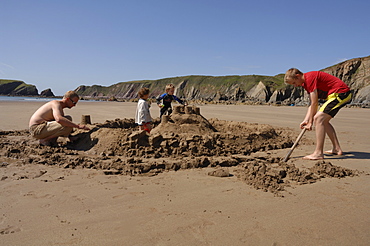 Building sandcastle, Marloes Sands, Pembrokeshire, Wales, UK