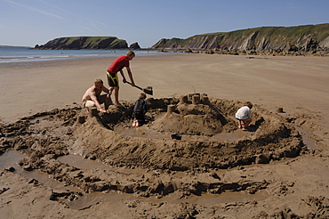 Building sandcastle, Marloes Sands, Pembrokeshire, Wales, UK