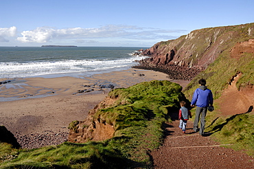 Mother and children going down steps to West Dale beach, Dale, Pembrokeshire, Wales, UK, Europe