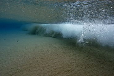 Breaking wave stirs up the sand underwater, Fernando de Noronha, Brazil, South America