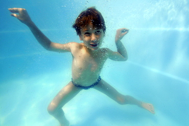 Young boy having underwater fun in the family pool, Guararema, Sao Paulo, Brazil, South America