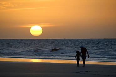 Woman and kid watch the sunset at Jericoacoara beach, Ceara, Brazil, South America