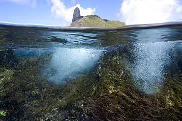 Morro do Pico and wave breaking over reef, split level, Fernando de Noronha, Pernambuco, Brazil, South America