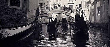 Gondalas going under a bridge. Venice, Italy