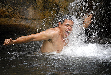 Man under a waterfall. Roccatederigh, Italy