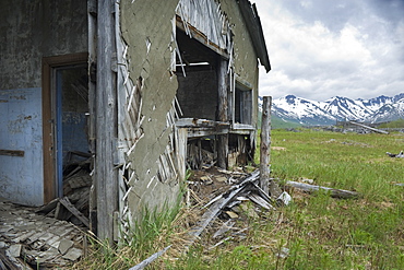 Abandoned Herring fishing settlement, tsunami damage, building debris, Landscape view of snow caped mountains, Yuzhnaya Glybokaya Bay (Bering Sea) Russia, Asia