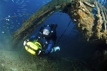 Mixed gas rebreather diver using scooter for mobility inside wreck.  Red Sea.