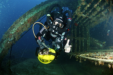 Mixed gas rebreather diver using scooter for mobility inside wreck.  Red Sea.