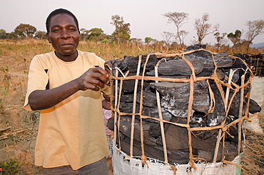 Charcoal maker selling charcoal on the side of the road, Zambia, Africa