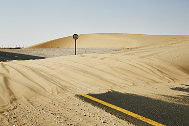 Sand dune blocks road in the Qatari desert, Qatar, Middle East