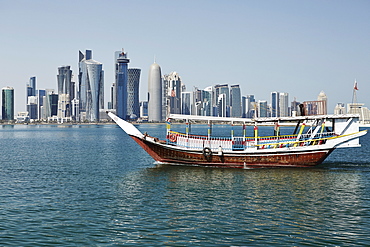 Downtown Doha with its impressive skyline of skyscrapers with authentic dhows in the bay, Doha, Qatar, Middle East