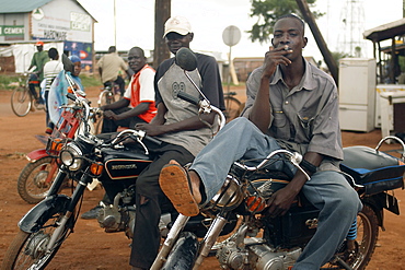 In the North West of Uganda is Gulu District.  These bikers are relaxing between errands in the centre of Gulu town. Gulu Town, Uganda, East Africa