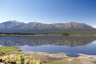 Perfect reflection of Alaskan mountain range in lake, Alaskan Interior.  Clear blue sky. The Interior, Alaska, USA