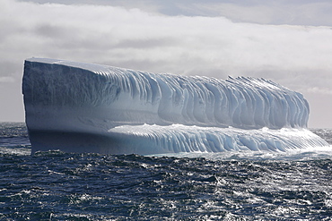 Huge intensely blue bench iceberg adrift in Antarctica.