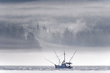 Low-lying clouds and fog create dramatic light on a fishing boat on the northern part of Kupreanof Island in Frederick Sound, Southeast Alaska, USA. Pacific Ocean.