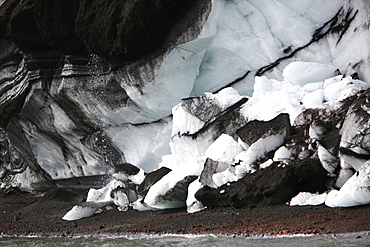 Close up views of glacial ice and ash after the 1969 eruption on Deception Island in Antarctica. Note the melting ice dropping suspended ash onto the beach.