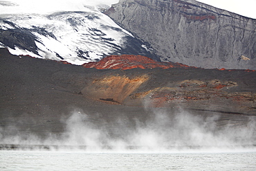 Close up views of glacial ice and ash after the 1969 eruption on Deception Island in Antarctica. Here thermal energy sends steam up in the seawater surrounding the recent ash flow.