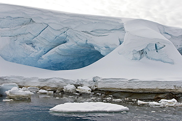 An ice cave formed on rocks at the Heroina Island Group near the Antarctic Peninsula.