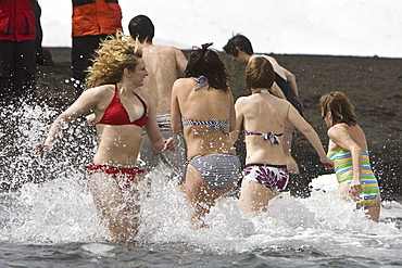 Lindblad Expeditions guests taking the "polar plunge" in Foster Harbor on Deception Island in Antarctica as part of expedition travel. NO MODEL RELEASES FOR THIS IMAGE.