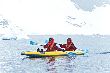 Lindblad Expeditions guests kayaking in snowstorm in Antarctica as part of expedition travel. NO MODEL RELEASES FOR THIS IMAGE.