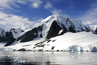 Reflections and snow covered mountains in Lemaire Channel in Antarctica.