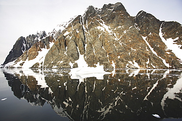 Reflections and snow covered mountains in the Lemaire Channel in Antarctica.