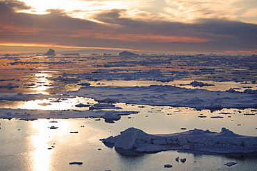 Sunset on fresh sea ice and tabular icebergs in the Weddell Sea, antarctica.