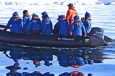 Reflected images of guests from the Lindblad Expedition ship National Geographic Endeavour on Zodiac tour around the Antarctic Peninsula