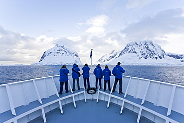 The Lindblad Expedition ship National Geographic Explorer transits Lemaire Channel in late evening light on the west side of the Antarctic peninsula in Antarctica