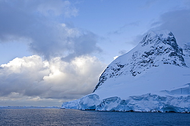 The Lindblad Expedition ship National Geographic Explorer transits Lemaire Channel in late evening light on the west side of the Antarctic peninsula in Antarctica