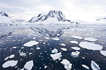 The Lindblad Expedition ship National Geographic Explorer transits Lemaire Channel in late evening light on the west side of the Antarctic peninsula in Antarctica