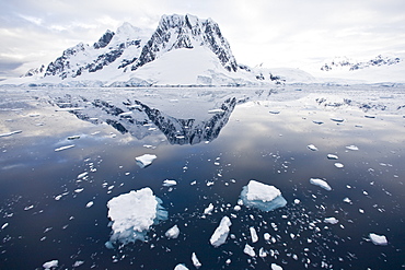 The Lindblad Expedition ship National Geographic Explorer transits Lemaire Channel in late evening light on the west side of the Antarctic peninsula in Antarctica