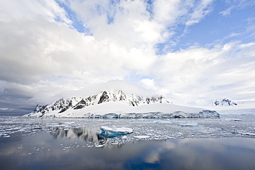 The Lindblad Expedition ship National Geographic Explorer transits Lemaire Channel in late evening light on the west side of the Antarctic peninsula in Antarctica