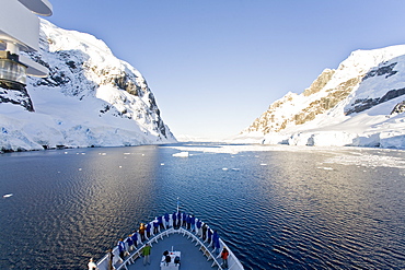 The Lindblad Expedition ship National Geographic Explorer transits Lemaire Channel in late evening light on the west side of the Antarctic peninsula in Antarctica