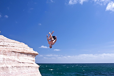 The Lindblad expedition ship National Geographic Sea Lion staff diving off the sandstone cliffs at Isla San Jose, Gulf of California (Sea of Cortez), Mexico