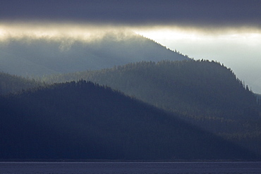 Dramatic early sunrise light over Admiralty Island from Chatham Strait in Southeast Alaska, USA. Pacific Ocean.