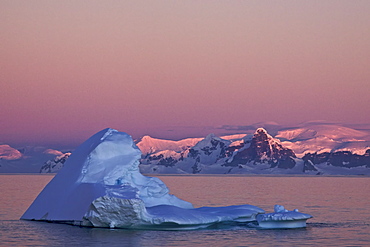 The Lindblad Expedition ship National Geographic Explorer in late evening light as the sun sets in the northwest side of the Antarctic Peninsula in Antarctica. 