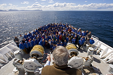 Exclusive Resorts guests from the Lindblad Expedition ship National Geographic Explorer pose for a photo on the bow