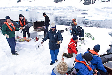 Guests from the Lindblad Expedition ship National Geographic Explorer enjoy a hot asado sandwich prepared by staff at BBQ on an ice floe near Adelaide Island, Antarctica