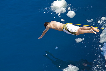 Guests from the Lindblad Expedition ship National Geographic Explorer take the Polar Plunge off ice floe in the Weddell Sea, Antarctica, Southern Ocean